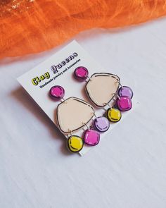 a pair of colorful earrings sitting on top of a card