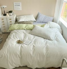 an unmade bed in a bedroom next to a white dresser with drawers on it