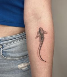 a woman's arm with a lizard tattoo on the left side of her body