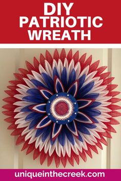 a red, white and blue paper flower hanging on a door with text overlay that reads diy patriotic wreath