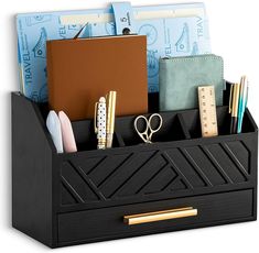 a black desk organizer with office supplies in the bottom compartment and ruler, pencils, pens, scissors, and other items