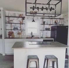 a kitchen with two stools next to an island