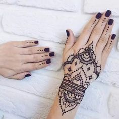 two hands with henna tattoos on them