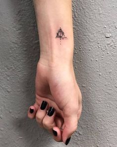 a small triangle tattoo on the wrist