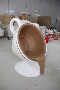 a white and brown chair sitting on top of a cement floor next to other chairs