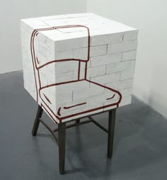 a chair made out of bricks sitting on top of a floor