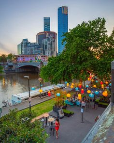 people are sitting at tables near the river