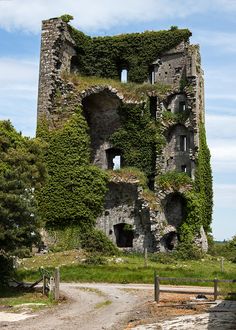 an old stone tower with ivy growing on it's sides and the windows missing