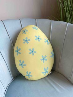 an egg shaped pillow sitting on top of a blue chair