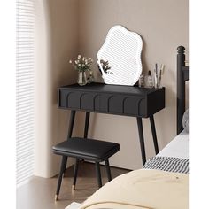 a black vanity table with a mirror and stool