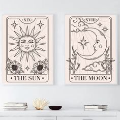 two sun and moon tarot cards hanging on the wall above a white dresser in a room