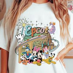 a woman wearing a white t - shirt with mickey mouse and goofy characters on it