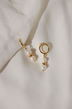 These dainty earrings are made with freshwater pearls and gold or platinum plated huggie hoops. This plating protects against wear and tear, tarnishing, and light contact with substances such as water. All earrings are handcrafted with care and custom made to meet your unique needs. Closure options: * Pierced gold hoops are hypoallergenic and nickel free (18 karat gold plated). * Pierced silver hoops are hypoallergenic and nickel free (platinum plated). * Clip on gold hoops are hypoallergenic an Dainty Pearl Earrings, خواتم خطوبة, Earrings Pearl Drop, Jewellery Aesthetic, Handmade Wire Jewelry, Jewelry Lookbook, Earrings Pearl, Earrings Dainty, Pearl Earrings Dangle