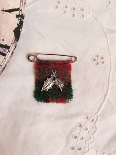 a pin with a bat on it sitting on top of a white cloth covered table