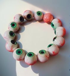 a bracelet made out of glass beads with green and red eyeballs on the inside