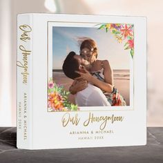 a wedding album with an image of two people hugging each other on the cover and text that reads our honeymoon