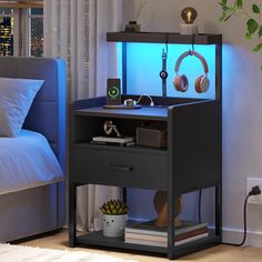 a night stand with headphones on it next to a bed and a plant in the corner