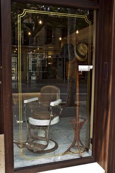 an old rocking chair and hat in a glass case on the outside of a building