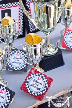 several trophies are sitting on a table with ribbons and tags attached to them, all decorated in different colors