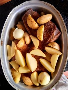 a bowl filled with meat and potatoes on top of a table