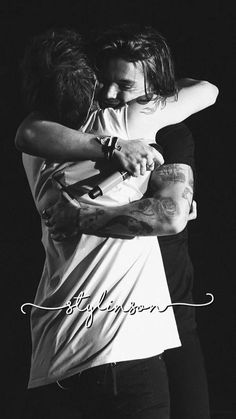 black and white photograph of two people hugging each other with the word love written on it