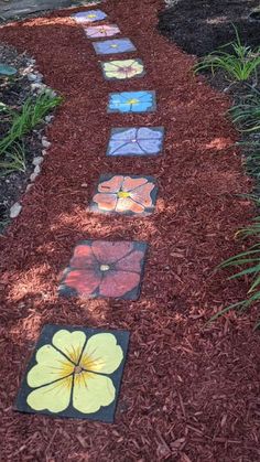 a pathway made out of stepping stones with flowers painted on them