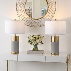 a white table with two lamps and a mirror