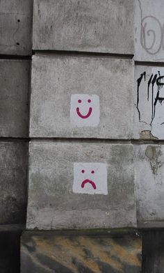 two cement blocks with smiley faces painted on them