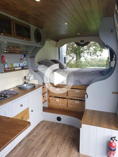 the interior of a camper with wood flooring and storage drawers on each side