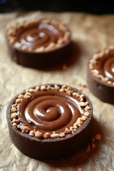 three chocolate desserts with peanut butter frosting and sprinkles on top