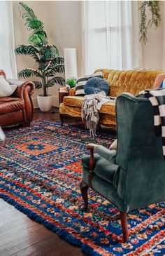 a living room with couches, chairs and rugs