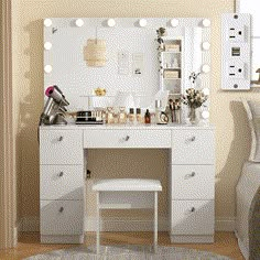 a white vanity with lights on it in a bedroom