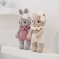 two crocheted stuffed animals sitting on top of a shelf next to each other