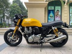 a yellow and black motorcycle parked in front of a building