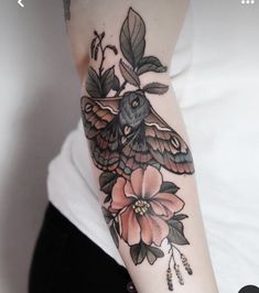 a close up of a person's arm with a tattoo on it and flowers