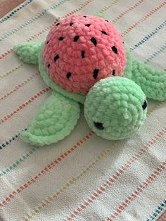 a crocheted turtle laying on top of a blanket