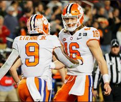 two football players standing next to each other in front of an audience at a game