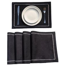 a place setting with black napkins and silverware