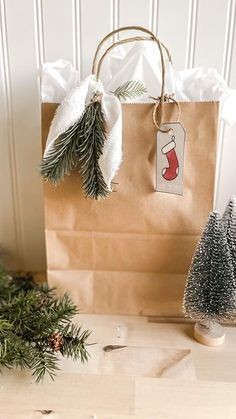 a brown paper bag sitting on top of a wooden table next to a small christmas tree