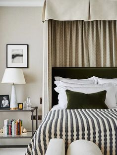 a bed with white and black bedspread next to a lamp on a table