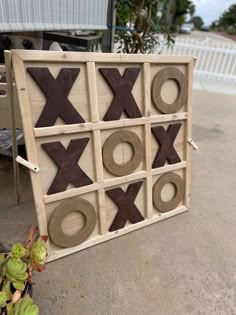 a wooden tic - tac - toe board with various shapes and sizes on it