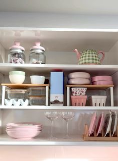 the shelves are filled with dishes, cups and other kitchen utensils on them