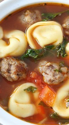 a close up of a bowl of soup with meatballs and veggies in it