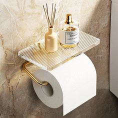 a toilet paper holder with two rolls of toilet paper and a bottle of perfume on it