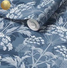 a blue floral wallpaper with white flowers and leaves on the bottom half of it