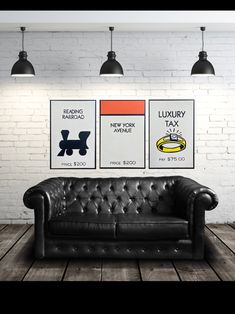 a black leather couch sitting in front of three posters