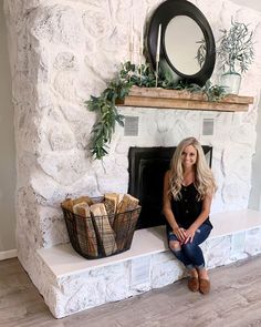 a woman sitting on a bench in front of a fireplace