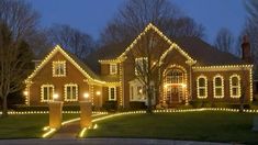 a large house with christmas lights on the front and side of it's windows