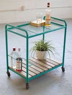 a small bar cart with two bottles and a potted plant