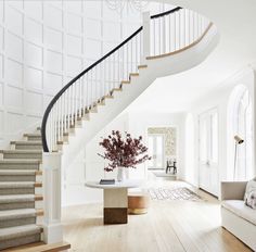 a living room filled with furniture and a spiral stair case next to a white couch